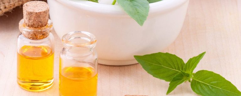 Kleine Glasflaschen mit goldenem Öl und frischen grünen Blättern, ideal für Fitness-Ernährung.