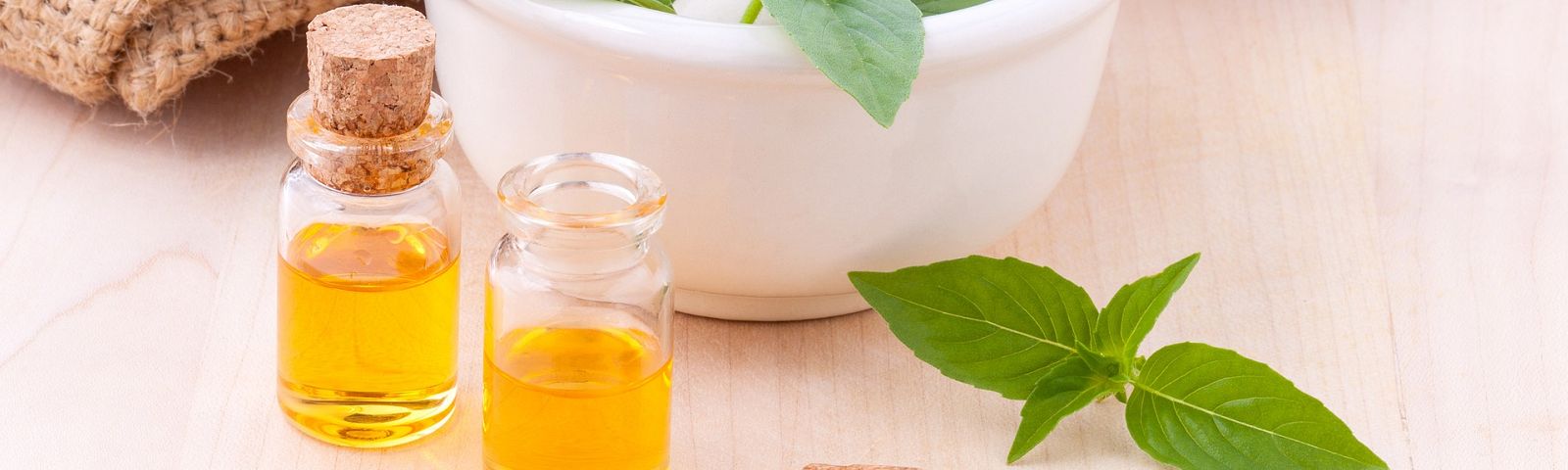 Kleine Glasflaschen mit goldenem Öl und frischen grünen Blättern, ideal für Fitness-Ernährung.