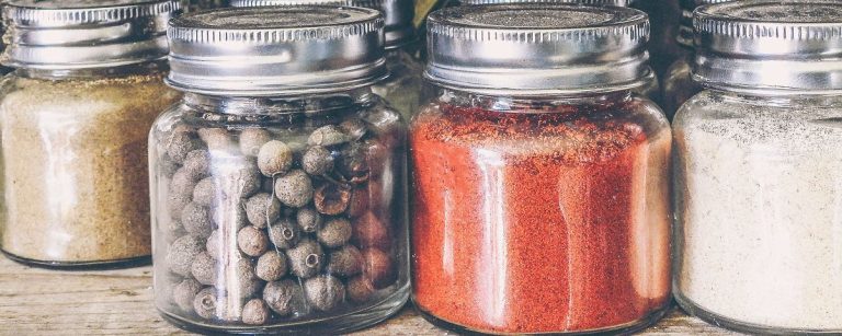 Gewürze für gesunde Ernährung: Kräuter, Gewürzkörner, Paprikapulver und mehr im Glas.