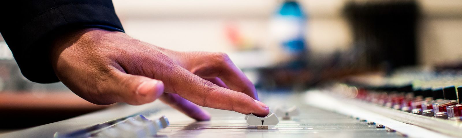 BF-Muzikale-workout-1600×480 Hand, die einen Schieberegler auf einem Mischpult bedient, Aufnahme und Bearbeitung von Fitness-Ernährungs-Audio.