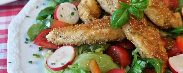 Hähnchen-Streifen mit Sesam auf Salat: Vitales Essen für Fitness-Fans.