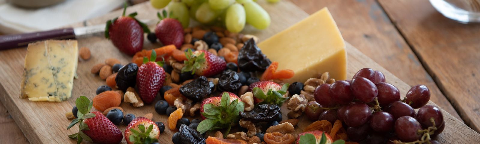 BF-eetgewoontes-1600×480 Fitness-Snack-Brett mit Käse, Beeren, Nüssen und Trockenfrüchten.