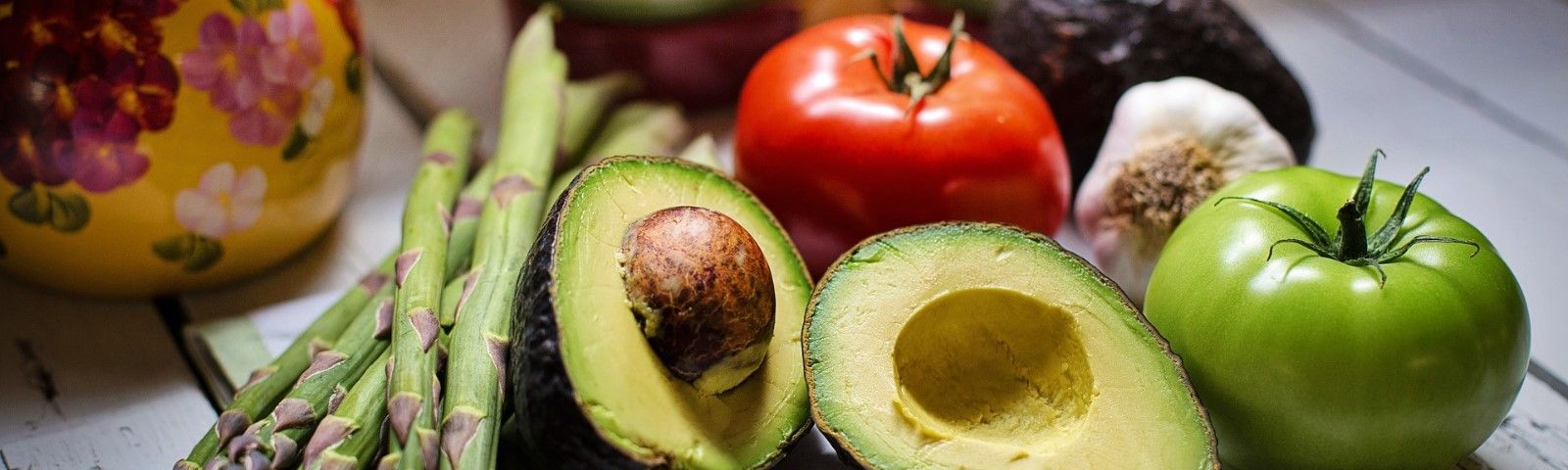 BF-vezels-1600×480 Frisches Gemüse für eine gesunde Ernährung: Avocado, Tomaten, Spargel und Knoblauch. Perfekt für Fitness-Rezepte.