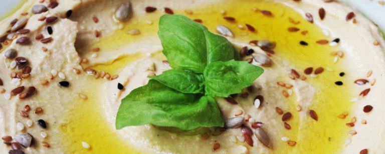 Köstliches Hummus mit Samen und Basilikum, perfekt für eine gesunde Ernährung.