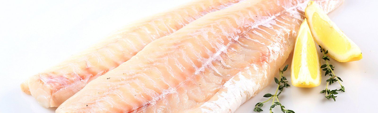 shutterstock-216843058groot Rohe Fischfilets mit Zitrone und Kräutern, ideal für eine gesunde Ernährung.