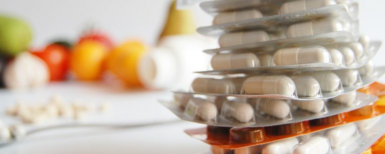 Pillen-Packungen und Früchte, ideal für Fitness-Ernährung, Nahrungsergänzungsmittel.