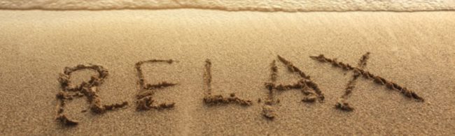 Wort "RELAX" in Sand geschrieben am Strand - Fitness und gesunde Ernährung für dein Wohlbefinden.