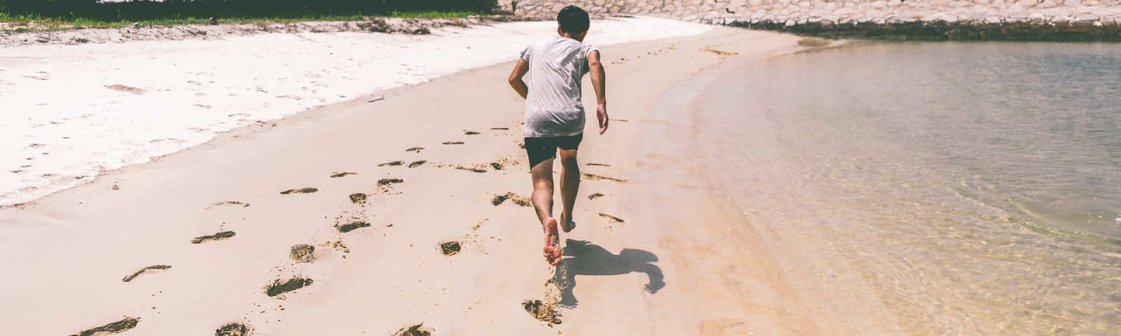 blote voeten 1600×480 Mann läuft am Strand, gesunde Ernährung für Fitness, erfrischendes Wasser, Sand und Sonne.