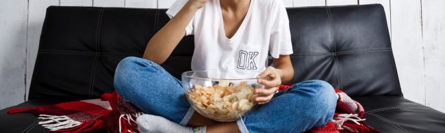 Person is eating chips on a couch.