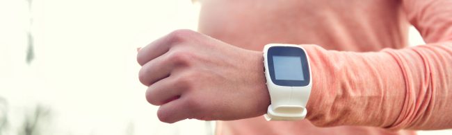 Nahaufnahme einer Person, die ihre Sportuhr überprüft, geeignet für eine Fitness-Ernährungsfirma.