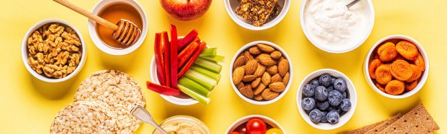 Gesunde Snacks: Nüsse, Obst, Joghurt und Gemüse für ein energiegeladenes Workout.