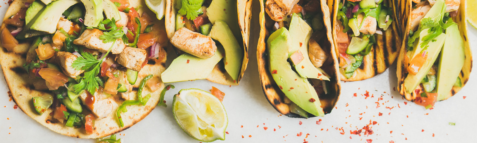 Whole-wheat tortilla next to a bright beetroot veggie wrap on a wooden board, surrounded by fresh salad ingredients.
