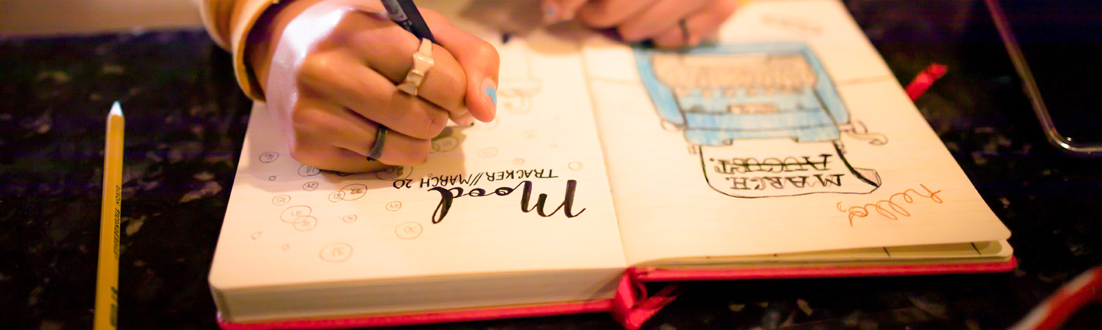 Close-up of a beautiful bullet journal spread with colorful markers, neatly organized index and symbol keys on a clean desk.