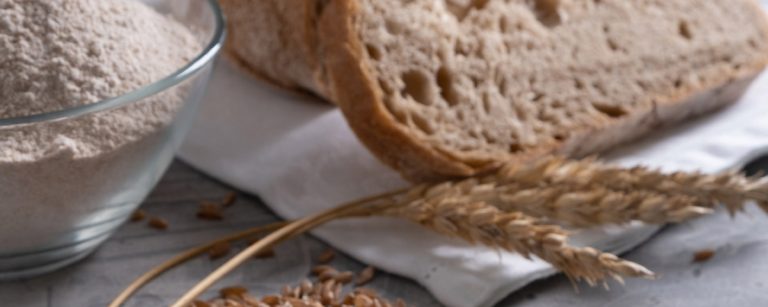 Close-up of a sliced dark brown whole-grain multigrain bread loaf, showing its rich texture and hearty grains.