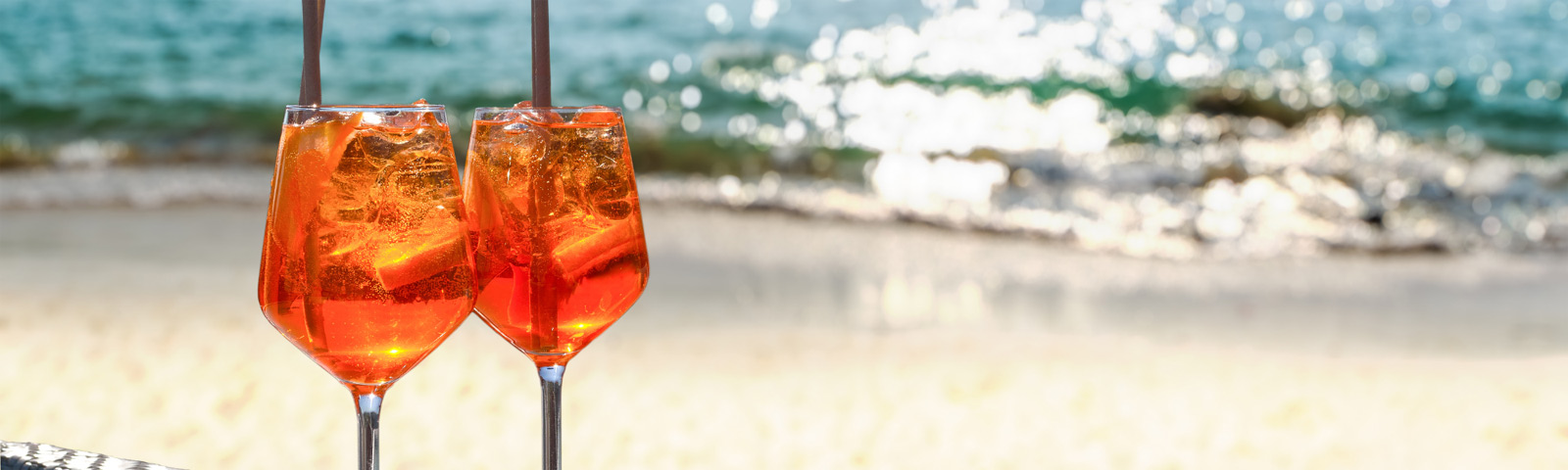 Light Aperol spritz with plenty of ice and an orange slice in a large wine glass