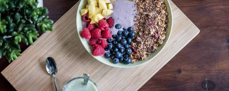 Buntes, gesundes Essen auf einem Tisch, darunter frisches Obst, Gemüse und Vollkornprodukte, inspiriert zur Ernährungsberatung